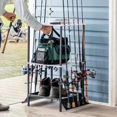 a man standing next to a rack filled with fishing rods