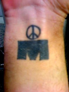 a person with a peace sign tattoo on their wrist