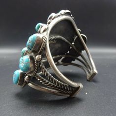 "MUSEUM WORTHY VINTAGE NAVAJO BRACELET DESCRIPTION: This exceptional cuff is from renowned Navajo artisan Jimmie Long who was active from the 1930s to the 1970s. Exquisite specimens of old Kingman turquoise are secure in smooth bezel, on a foundation of heavy gauge vintage sterling silver. Four bars of solid and twisted hand-pulled silver form the foundation, while applied raindrops and twisted silver adorn the face of the cuff. This museum quality bracelet will be a cherished addition to your c Vintage Turquoise Bracelet For Festival, Antique Turquoise Adjustable Bracelet, Antique Adjustable Turquoise Bracelet, Vintage Turquoise Cuff Bracelet For Festival, Turquoise Vintage Cuff Bracelet For Festival, Cluster Bracelet, Navajo Bracelet, Cluster Bracelets, Kingman Turquoise