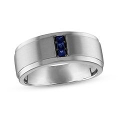 a men's wedding band with blue sapphire in the center and two black diamonds on each side