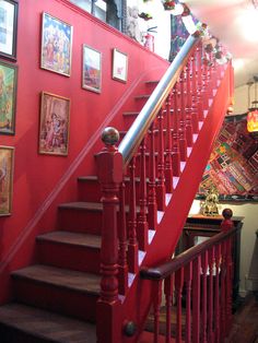 a red staircase with pictures on the wall