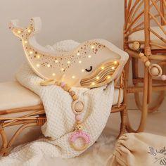 a wooden rocking chair with a white blanket and light up toy whale on it's back