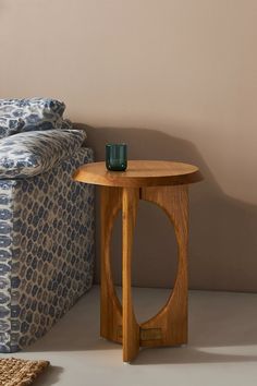 a wooden table sitting next to a couch with a cup on top of the table