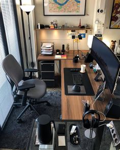 a desk with a computer and headphones on it in front of a large map