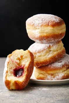 three powdered donuts stacked on top of each other with a bite taken out of one