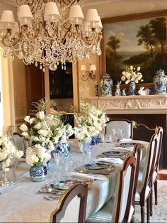 a dining room table is set with blue and white flowers