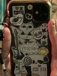 a person holding up a phone case with stickers on it