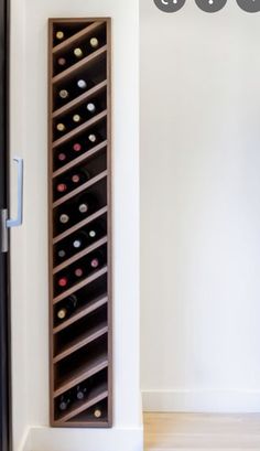 a wine rack is shown in the corner of a room with white walls and wood floors