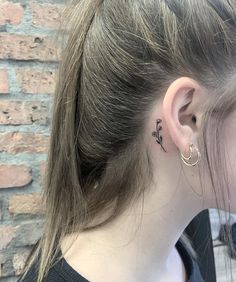 a woman with a small tattoo behind her ear