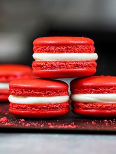 red velvet cookies with white frosting stacked on top of each other