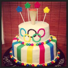 a multi - tiered cake decorated with olympic symbols