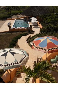 an outdoor pool with umbrellas and chairs next to it