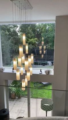 a living room filled with furniture next to a large glass window covered in hanging lights