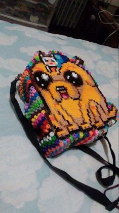 a beaded dog purse sitting on top of a bed