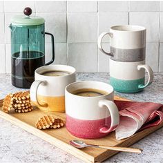 two coffee mugs sitting on top of a wooden tray