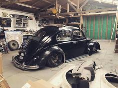 an old black car parked in a garage