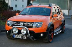 an orange dacia parked on the street