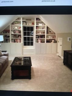 a living room filled with furniture and bookshelves in an attic style home office