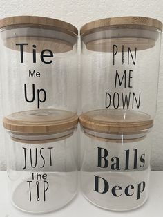 two clear jars with wooden lids that say tie me up, pin me down, just the tip