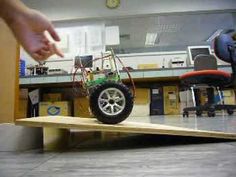 a hand is pointing at a toy car on a table