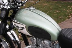 a close up of a motorcycle parked on the side of the road with grass in the background