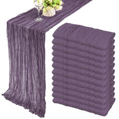 purple table runner and vase with flowers on it