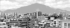 black and white photograph of cityscape with mountains in the backgrouds