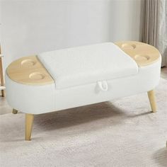 a white foot stool with wooden legs and buttons on the top, in a living room