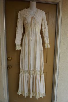 Size 13 Gunne Sax prairie dress fits smaller - please see measurements.  Zips in the back with adjustable tie at the back of the waist. Condition - has one small spot mid skirt to the side - see last photo.Measurements taken across front lying flat18" across front armpit to armpit14" across front of waist (ties tighter)59" length Long Sleeve Lace Maxi Dress With Lace Trim, Lace Trim Maxi Dress For Fall, Maxi Dress With Lace Trim For Fall, Beige Long Sleeve Maxi Dress With Lace Trim, Fall Maxi Dress With Lace Trim, Bohemian Long Sleeve Lace Maxi Dress, Cottagecore Victorian Dress With Lace Trim And Long Sleeves, Bohemian Long Sleeve Maxi Dress With Lace Trim, Elegant Fitted Long Sleeve Peasant Dress