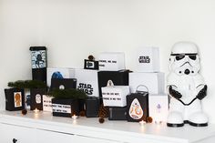 a star wars themed display on top of a white dresser next to candles and other items