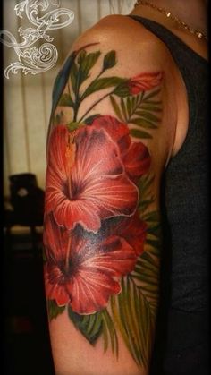 a woman's arm with flowers and leaves on it