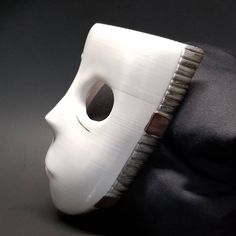 a white mask sitting on top of a black cloth