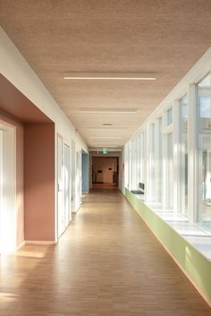 an empty hallway with lots of windows on both sides