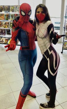 two women dressed as spider - man and the amazing spiderman are standing in a store