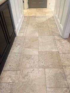 a tile floor that has been cleaned and is in the middle of a hallway with white trim