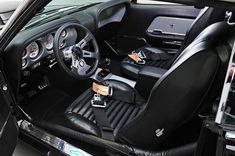 the interior of a sports car with black leather seats and steering wheel, including an automatic