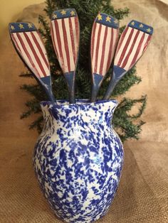 a blue and white vase with five american flags in it