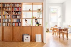 a man and woman standing in front of a bookshelf