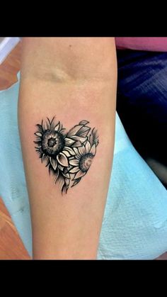 a sunflower heart tattoo on the right arm and leg, with flowers in the middle