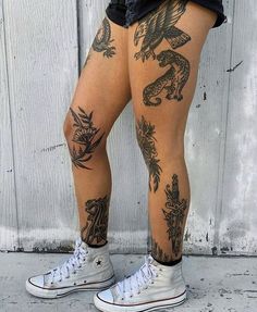 a person with tattoos on their legs standing in front of a door