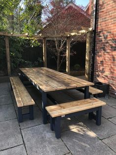 a wooden picnic table with benches next to it