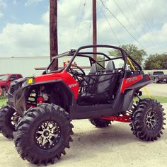 a red four - wheeled vehicle parked in a parking lot