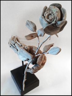 a sculpture of a flower on a black stand