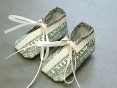 two bundles of money tied up to each other with white string on them, sitting on top of a gray surface