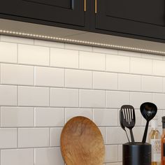 kitchen utensils and cooking utensils are sitting on the counter in front of black cabinets