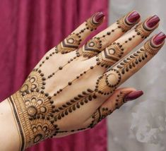 a woman's hand with henna tattoos on it