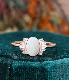 an opalite and diamond ring sits on a velvet cushion