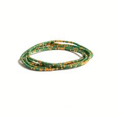 Beautiful delicate wrap bracelet, wraps around your wrist 5 times. Lovely color combination of green with a hint of golden seed beads which gives the bracelet a lovely sparkle. M A T E R I A L * Delica Seed beads from Miyuki ( 2 mm) green & gold * Very strong elastic S I Z E Size medium, 86 cm ( 34 inch), 6.7 inch when wrapped, fits the normal to small wrist. Can be made in any size ( please sent me a message with your order and it will be made for you) S H I P P I N G * All orders are wrapp Green Beaded Wrap Bracelet, Green Multi-strand Jewelry With Tiny Beads, Adjustable Multi-strand Wrap Bracelet With Tiny Beads, Green Multi-strand Hand Wrapped Beaded Bracelets, Green Bohemian Multi-strand Beaded Bracelets, Western Bracelets, Peridot Bracelet, Essential Oil Diffuser Bracelet, Boho Wrap Bracelet