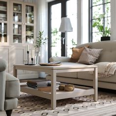 a living room filled with furniture and a coffee table in front of a large window