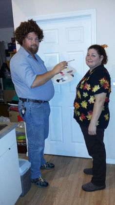 a man standing next to a woman holding a paintbrush